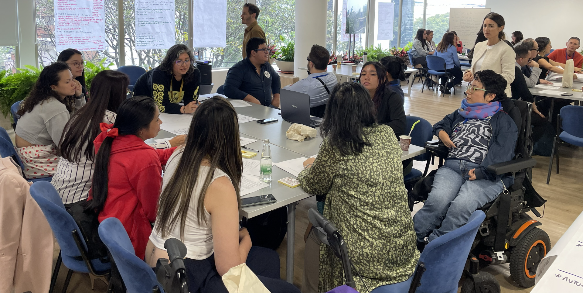 Several people with and without disabilities engage in a conversation during a workshop
